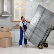 Residential movers packing a fridge